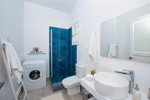米克諾斯城的住宿－Vaqueros，浴室配有卫生间水槽和洗衣机。