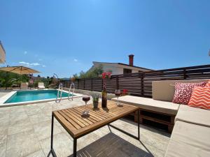 a patio with a couch and a table with wine glasses at Charming Villa Ira with Pool in Krk