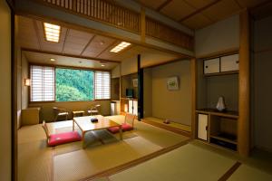 日田市にある新紫陽のテーブルと椅子、窓が備わる客室です。