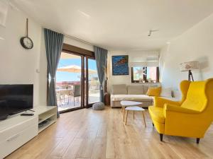 a living room with a couch and a yellow chair at Charming Villa Ira with Pool in Krk