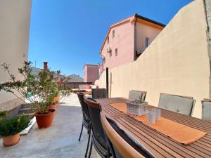 a wooden table and chairs on a balcony at Charming Villa Ira with Pool in Krk