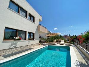 a swimming pool in front of a house at Charming Villa Ira with Pool in Krk