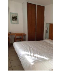 - une chambre avec un lit blanc et un bureau dans l'établissement Hôtel Mer et Forêt, à Saint-Trojan-les-Bains