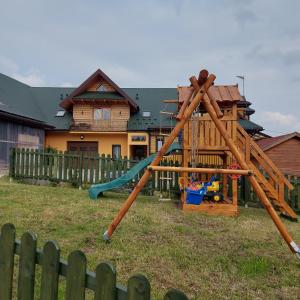 einen Spielplatz in einem Hof vor einem Haus in der Unterkunft Pokoje gościnne u Galusia in Mochnaczka Wyżna