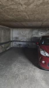 a red car parked in a parking garage at CASITA aux portes de paris in Bagneux
