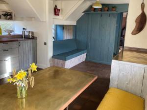 uma cozinha com uma mesa e um armário azul em Whichford Mill Barn- Soulful retreat. em Shipston on Stour
