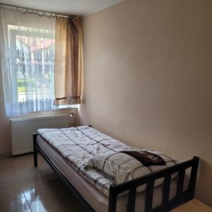 uma pequena cama num quarto com uma janela em Noclegi Starogard em Starogard Gdański