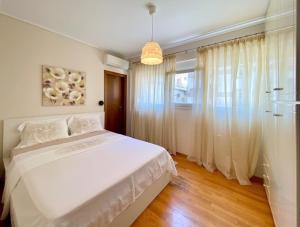 a bedroom with a white bed and a window at East Coast Thessaloniki in Thessaloniki