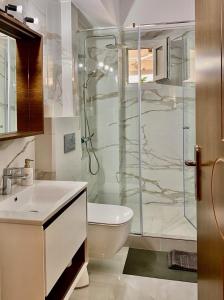 a bathroom with a shower and a toilet and a sink at East Coast Thessaloniki in Thessaloniki +13 photos