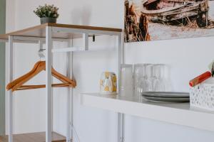 a white kitchen with a white shelf and a table at Ferienzimmer in Dargen