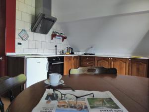 una cocina con una mesa con un periódico. en Apartma Dobra misel, en Bovec