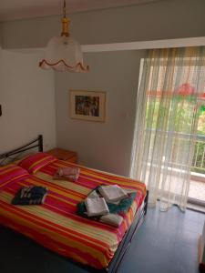 1 dormitorio con 1 cama con toallas y ventana en Sermili's House, en Gerakini