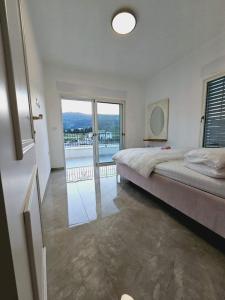 1 dormitorio con 1 cama grande y balcón en הבית הלבן, en Kiryat Shemona