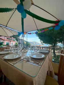 een tafel met glazen en uitzicht op een rivier bij Hotel Pineta in Laigueglia