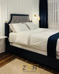 ペヤにあるZen Apartments Pejëのベッドルーム(白いシーツを使用した大型ベッド1台付)