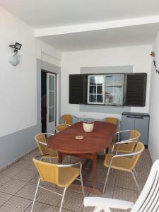 a dining room with a wooden table and chairs at Milfontes Beach House in Vila Nova de Milfontes