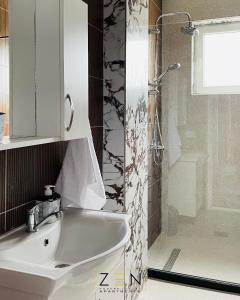 een badkamer met een wastafel en een douche bij Zen Apartments Pejë in Peje