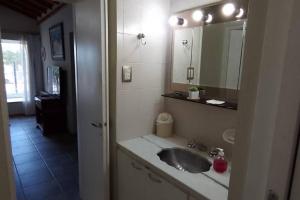 a bathroom with a sink and a mirror at La Laguna - Casa familiar a 5 cuadras de la playa. in Puerto Madryn