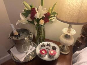 a table with a vase of flowers and cupcakes on it at The 1425 Inn in Columbia