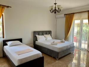 1 Schlafzimmer mit 2 Betten und einem Kronleuchter in der Unterkunft Vila Sidi in Ksamil