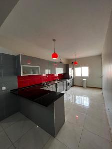 a kitchen with red and gray cabinets and appliances at Hellen Apartament in Praia