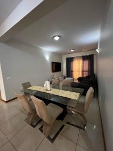 a dining room with a table and chairs and a couch at Hellen Apartament in Praia