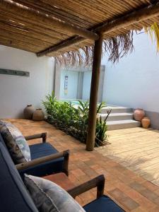 a patio with two couches and a wooden roof at Hotel Boutique Perainda in Trancoso