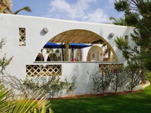 una casa blanca con un arco en un patio en Chambre d'hôtes, Dar l'air du temps en Aghīr