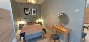 a bedroom with a bed and a mirror and a table at Loft apartament in Giżycko