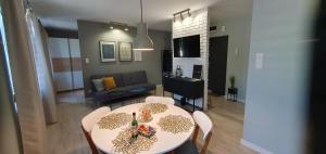 a living room with a table and chairs and a couch at Loft apartament in Giżycko +9 photos