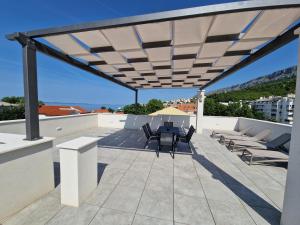 d'une terrasse sur le toit avec une table et des chaises. dans l'établissement Skockica, à Dugi Rat