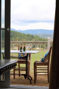 una mesa con 2 copas de vino en el balcón en Guesthouse Elena , Vatos, Corfu, en Vátos