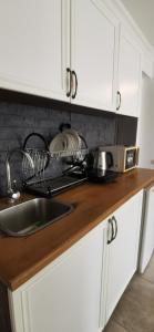 a kitchen counter with a sink and a microwave at Batumi-Gonio First line Apartment in Gonio