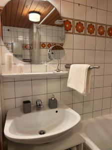 a white bathroom with a sink and a mirror at An Wanderwegen gelegen mit Terrasse und Boxspringbett in Sasbachwalden