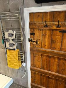 bagno con porta in legno in camera di Lluest a Llanddewi-Brefi