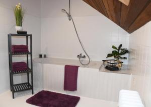 een badkamer met een bad en paarse handdoeken bij Ferienhaus Dröfter Blick in Monschau