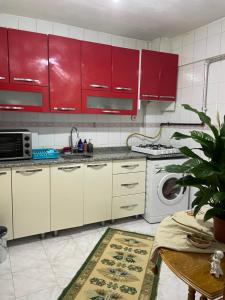 a kitchen with red cabinets and a washing machine at A room which close to the centre of Istanbul , 10 minutes to metro in Istanbul