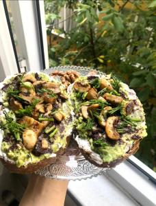 a person holding a plate with a sandwich with broccoli and mushrooms at A room which close to the centre of Istanbul , 10 minutes to metro in Istanbul