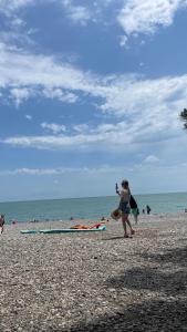 Ein paar Leute gehen am Strand spazieren in der Unterkunft Дом Aframe Пицунда in Pizunda