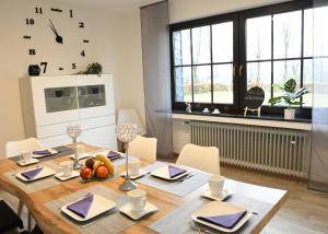 Ferienhaus Dröfter Blick في مونشاو: غرفة طعام مع طاولة خشبية عليها فاكهة
