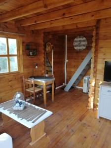 Massay的住宿－Agréable chalet en bois et son extérieur，小屋内带桌子和楼梯的房间