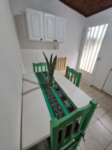 a white table with green chairs in a kitchen at Depto confortable para 4 Personas in Posadas