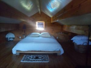 Massay的住宿－Agréable chalet en bois et son extérieur，木制客房内的一间卧室,配有一张床