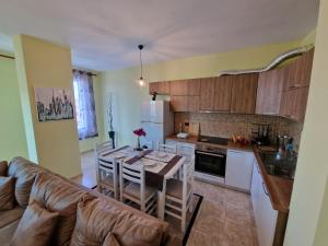 a kitchen and dining room with a table and a couch at Donel Apartment in Durrës