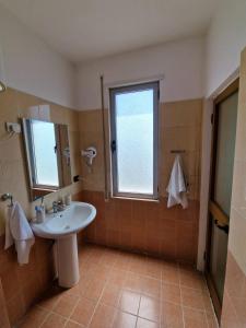 een badkamer met een wastafel en een raam bij Donel Apartment in Durrës