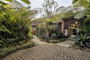 een huis met een stenen loopbrug in een tuin bij Roshan Ubud Villa in Ubud