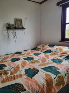 uma cama com uma colcha colorida num quarto em Chalet Happiness met heerlijk terras en tuin in Kortgene. em Kortgene