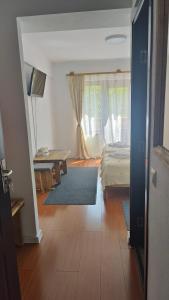 - une chambre avec un lit, une table et une fenêtre dans l'établissement Pensiunea Trei Brazi Arieseni, à Arieşeni