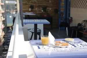 een glas sinaasappelsap en een bord eten op een tafel bij The Exiles Hotel in Sliema