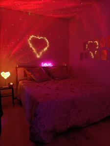 - une chambre dotée d'un lit avec un panneau de néons dans l'établissement CocoonSPA LoveRoom Jacuzzi, à Toulouse